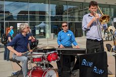 Die Jazzband Blue Alley spielt auf der B&uuml;hne. Sie bestehen aus einem Schlagzeuger, einem Pianisten und einem Trompeter im Vordergrund.