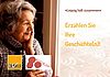 Seniorin mit grauen welligen Haar steht vor dem Fenster und blickt hinaus, dabei h&auml;lt sie ihre Hand an das Gesicht. Weiter steht auf dem Bild: Leipzig h&auml;lt zusammen. Erz&auml;hlen Sie ihre Geschichte