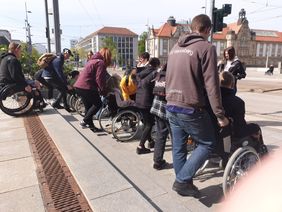 Jugendliche versuchen sich im Rollstuhl zu fahren