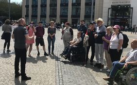Eine Gruppe von Menschen mit Behinderung w&auml;hrend einer inklusiven Stadtf&uuml;hrung