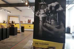 Ausstellungsst&uuml;cke im Bergbaumuseum: Eine gro&szlig;e Tafel mit einem Schwarz-Wei&szlig;-Foto erkl&auml;rt, dass es sich um den Technik-Teil der Ausstellung handelt.
