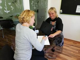 Zwei Frauen am Tisch mit Laptop im Gespr&auml;ch