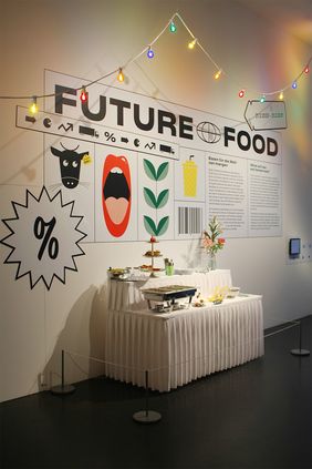 Tafel mit Essen, Girlande oben dr&uuml;ber - Partystimmung und dem Titel Future Food zur Ausstellung im Hygiene-Museum