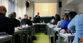 Ray R&uuml;hle h&auml;lt ein Referat vor vielen Teilnehmenden