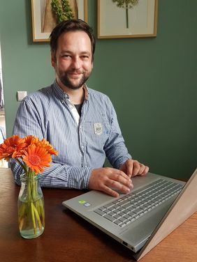 Mann mit Bart sitzt am Laptop