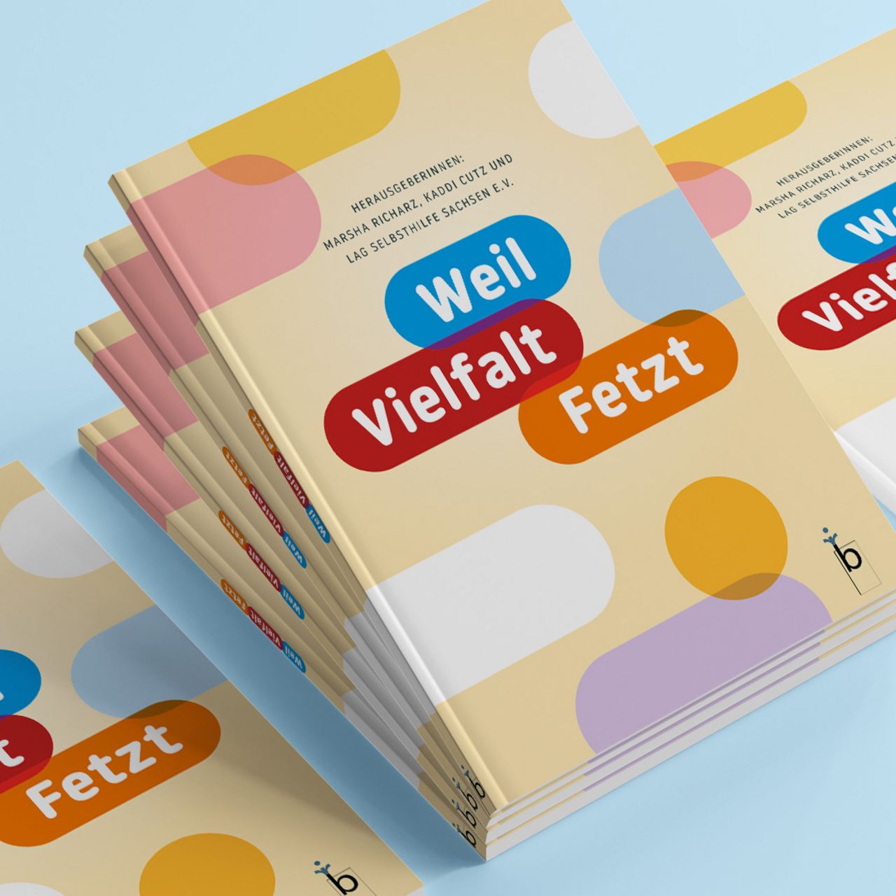 Ein Stapel mit Büchern. Auf Ihnen steht "Weil Vielfalt fetzt" in bunten Farben.