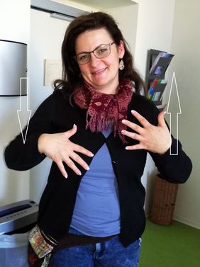 Frau mit Brille und langen Haaren zeigt die Geb&auml;rde spielen