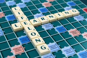 [Translate to Leichte Sprache:] Ein Scrabble-Brett auf dem die Worte "Livelong" und "Learning" im Buchstaben "E" gekreuzt miteinander verbunden sind.