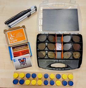 [Translate to Leichte Sprache:] Verschiedene Materialen des Projektes Challenge Inklusion liegen auf einem Tisch. Zu sehen sind ein zusammen geklappter Langstock, ein aufgeklappter Koffer mit Simulationsbrillen f&uuml;r verschiedene Augenkrankheiten, das Kartenspiel "Dumme Fragen gibt es nicht" und ein H&ouml;r-Memory-Spiel.