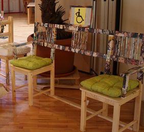 Holzbank mit zwei Sitzen und in der Mitte Platz f&uuml;r den Rollstuhl