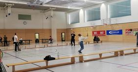 Sporthalle mit Sportlern, die Federball spielen