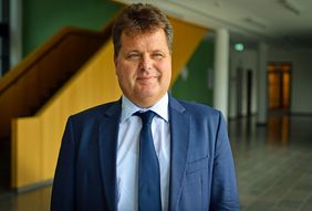 Mann mit braunen kurzen Haaren in Anzug und Krawatte